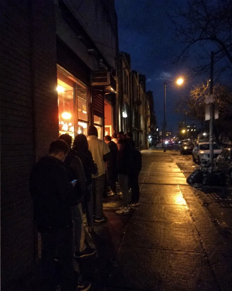 People waiting in line on the sidewalk after midnight